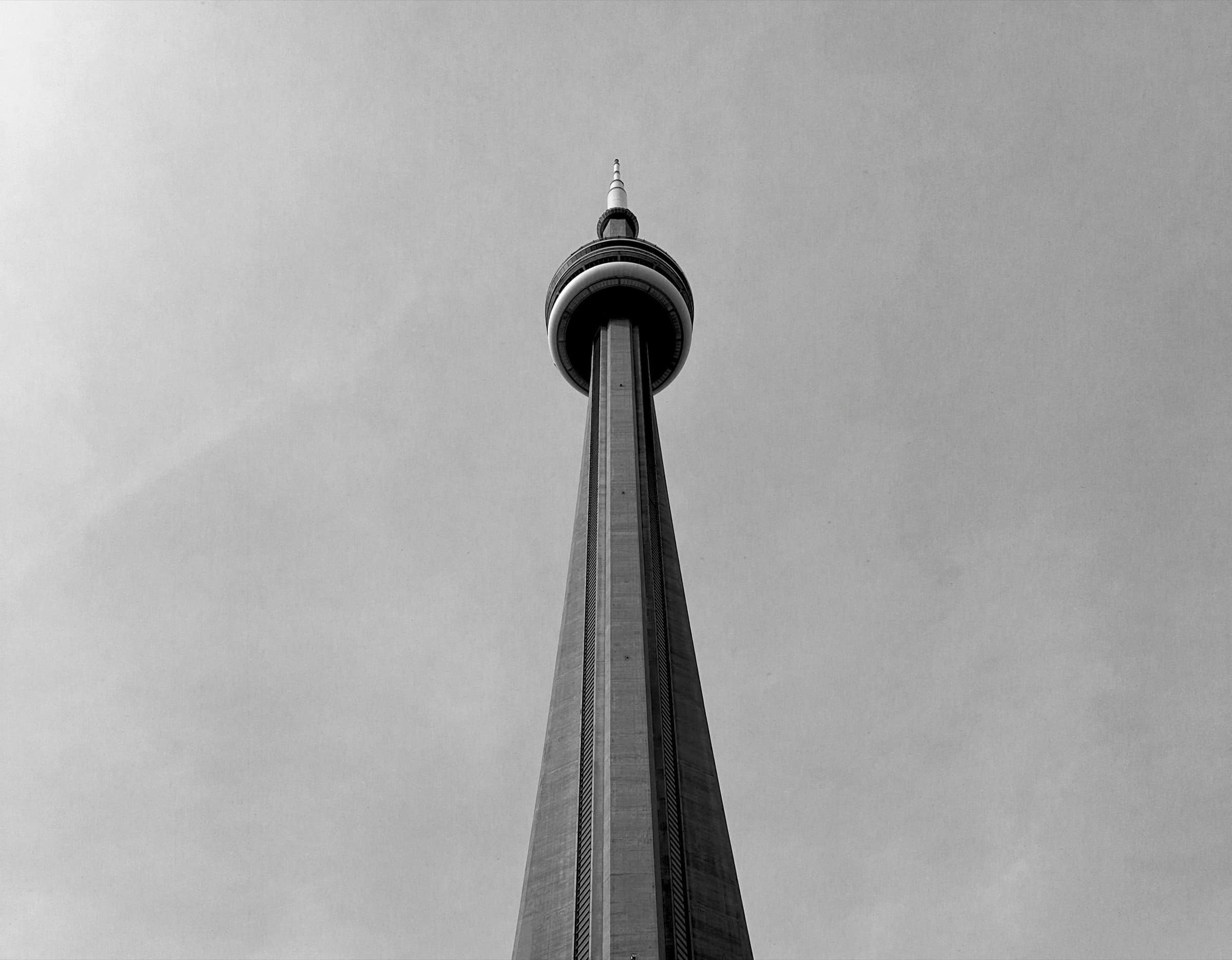 CN Tower seen from below against a pale sky